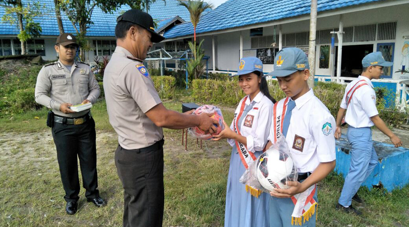 Kasat Binmas Polres Melawi, AKP T. Pardamean Marbun, ketika menyerahkan bantuan bola kaki dan buku kepada pelajar SMA N 1 Belimbing