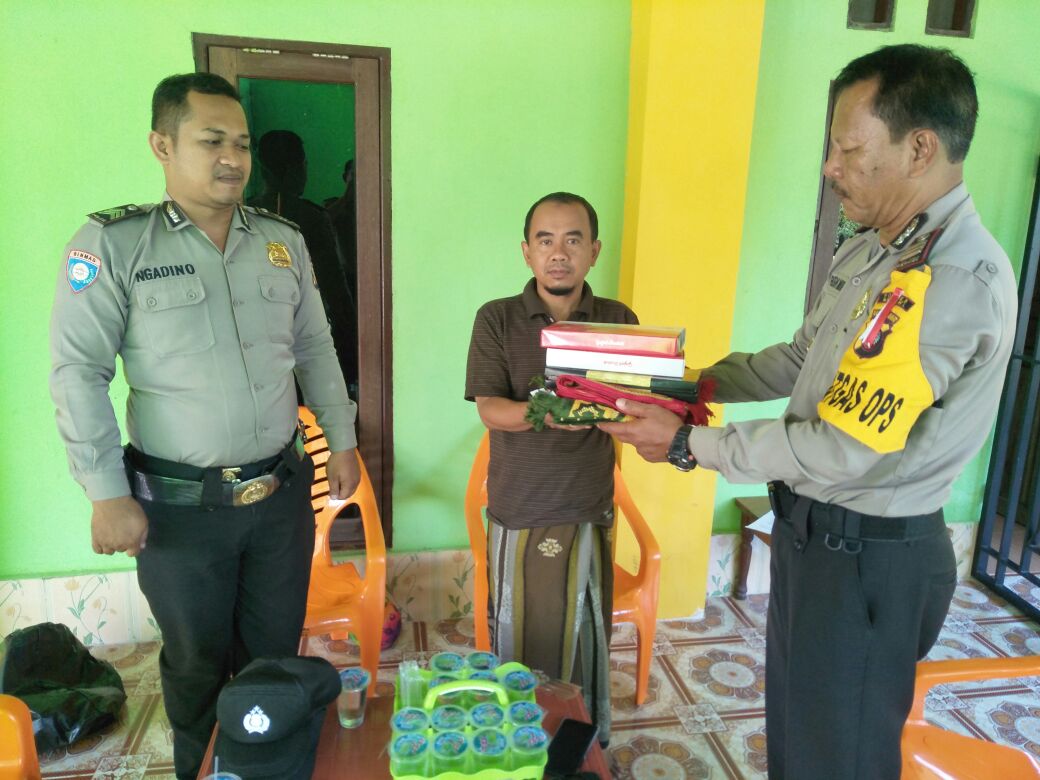Kasat Binmas Polres Melawi, TP Marbun ketika menyerahkan sarana ibadah berupa sejadah dan sarung kepada Ustad Ali Murtado selaku pimpinan Pesantrenan Darul Fallah Nanga Pinoh---Istimewa