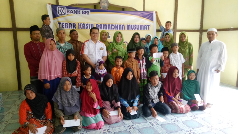 Muslimat NU berfoto bersama anak yatim dan kaum duafa yang menerima bingkisan Idhul Fitri 