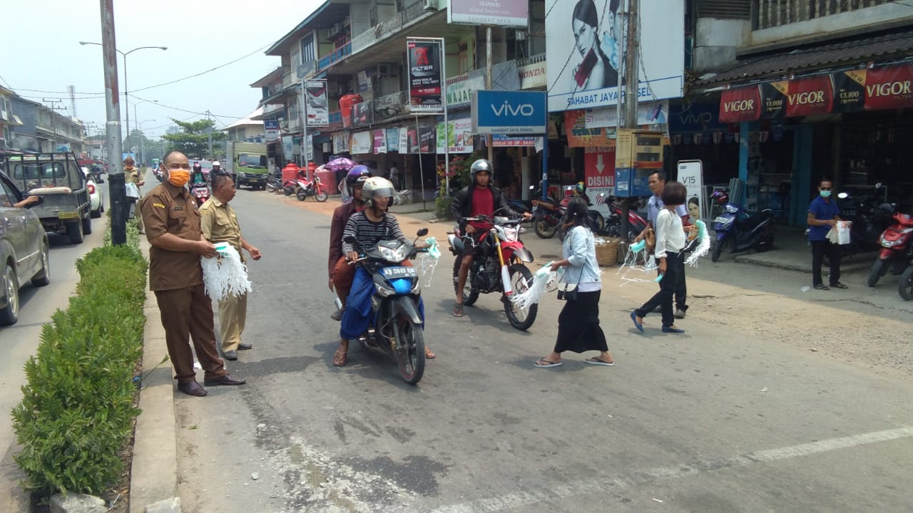 Pembagian Masker yang dilakukan pihak BPBD Melawi di Jalan Juang Nanga Pinoh tepatnya di trafickligh tugu juang