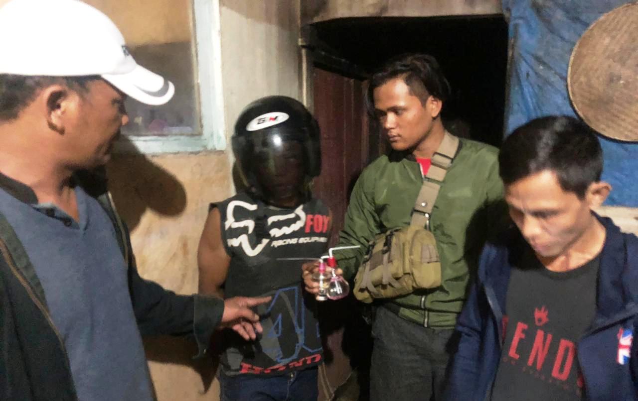 Tersangka Y (40) menggunakan helm usai penggeledahan kediamannya (Dedi Irawan/Kalimantan-News)