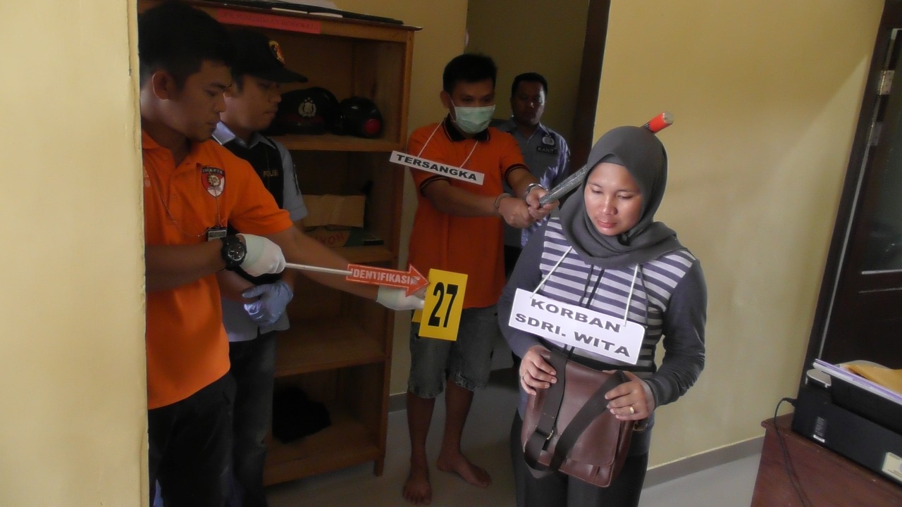 Tersangka DV saat mempergakan adegan ke 27, dimana Ia memukul kepala korban bernama Wita (Dedi Irawan/KN)