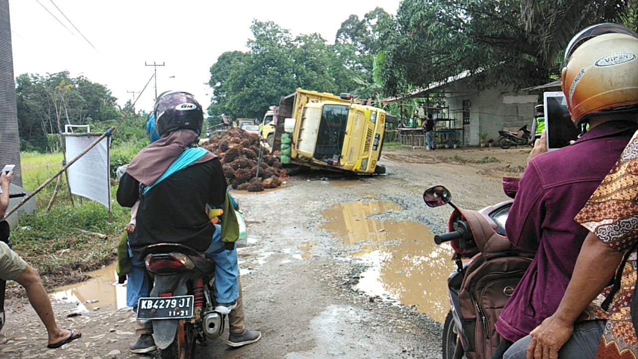 Salah satu truk angkutan sawit yang terbalik di jalan Nanga Pinoh-Sintang, tepatnya di Desa Tanjung Tegang. Truk tersebut tumbang ketika kehilangan keseimbangannya saat melalui jalan yang berlubang (Ist/KN)