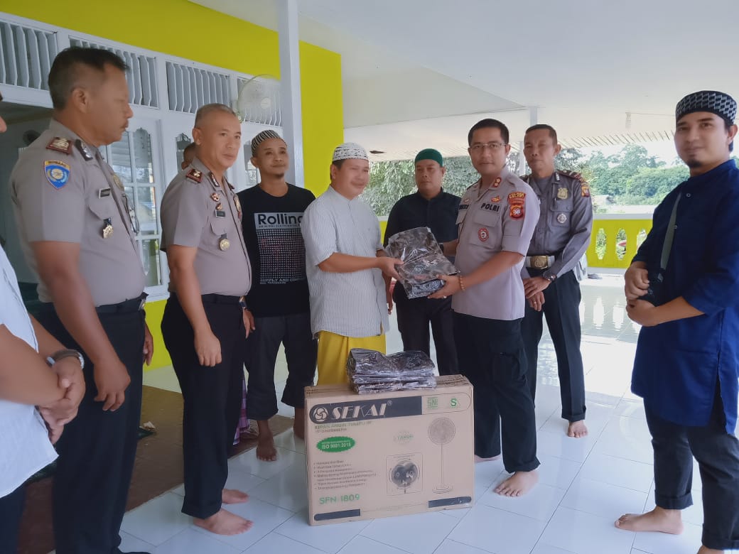 Kapolres Melawi, AKBP Tris Supriadi, didampingi Waka Polres Melawi, Komlol Jajang dan anggota lainnya saat menyerahkan bantuan kepada pengurus Masjid As-Shobirin. (Dedi Irawan /KN) 
