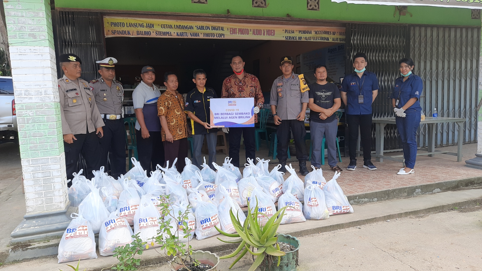 Kepala Cabang BRI Melawi, Setyo Agung Yulianto menyerah bantuan paket bahan Sembako secara simbolis kepada agen BRILink Tanjung Tengang, untuk disalurkan kembali ke warga kurang mampu. (Dedi Irawan/KN) 