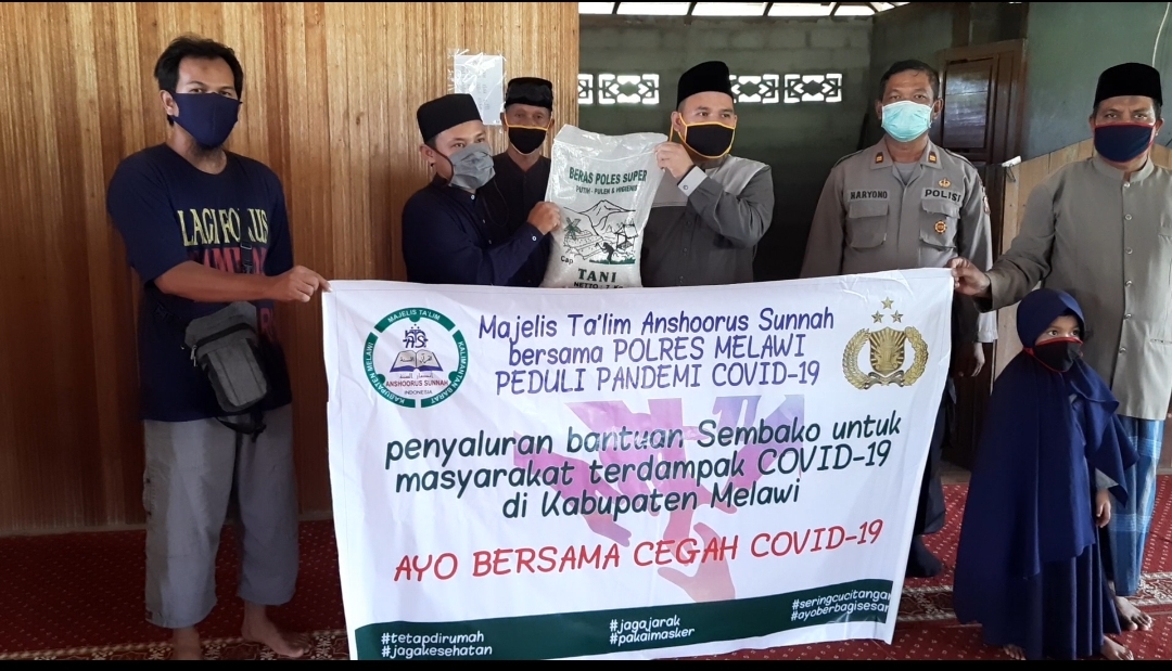 Pengasuh Majelis Ta'lim Anshoorus Sunnah, Ustadz Al Pindi, didampingi Kasat Binmas Polres Melawi, Iptu Hariono, saat menyerahkan bantuan kepada pihak Pondok pesantren Nahldatul Wathan. (Dedi Irawan/KN) 