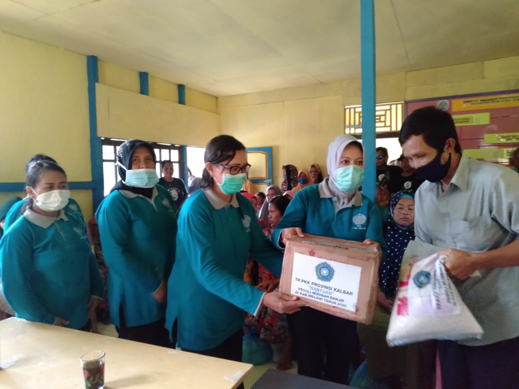 Ketua TP PKK Melawi, Hj Nurbetty Eka Mulastri Panji saat menyerahkan bantuan kepada warga. (Ist) 