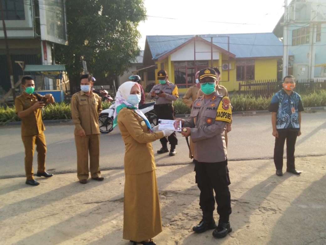 Pjs. Bupati Melawi, Linda Purnama saat menyerahkan brosur sosialisasi penerapan prokes kepada Kapolres Melawi, AKBP Tris Supriadi. (Ist) 