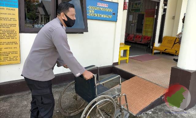 Seorang Polisi Mendorong Kursi Roda di Polres Sekadau