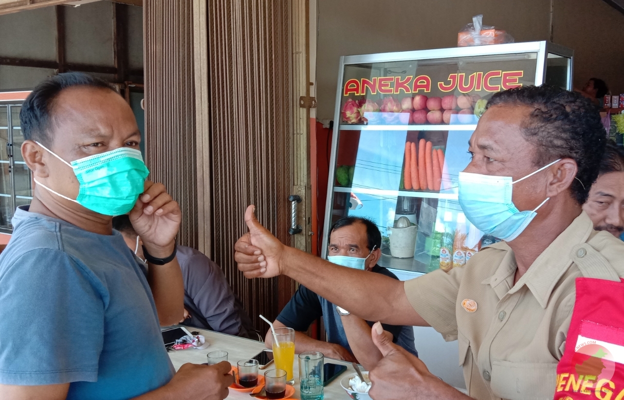 Kasi pencegahan, BPBD Melawi, Andi Kulu saat memasangkan masker kepada seorang warga. (Foto. Dedi Irawan) 