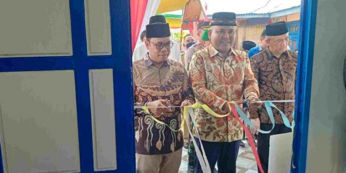 Bupati Melawi, H. Dadi Sunarya Usfa Yursa didampingi Anggota DPRD Provinsi, Ritaudin saat memotong pita peresmian gedung balai pertemuan Desa Paal---Dedi Irawan