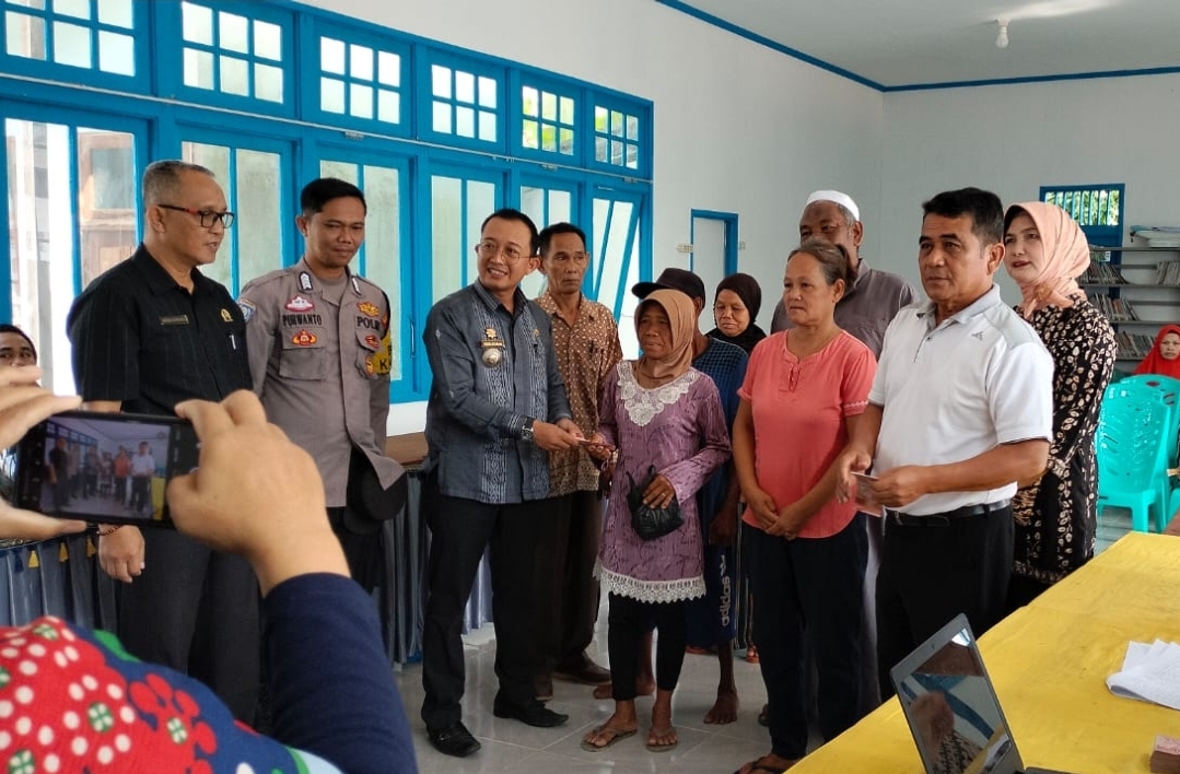 Camat Nanga Pinoh, Hendra Permana didampingi Kades Paal dan Forkopindes lainnya saat menyerahkan BLT DD kepada Keluarga Penerima Manfaat. (Dedi Irawan) 