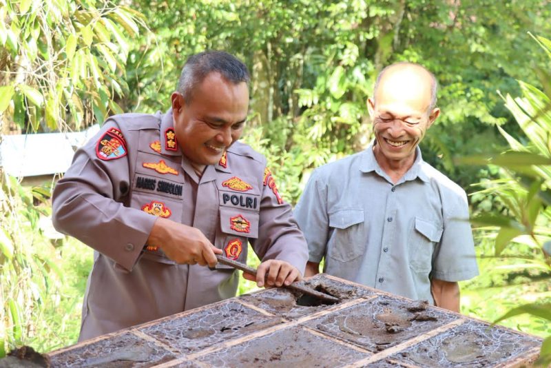 Kapolres Melawi AKBP Harris Batara Simbolon bersama pemilik peternakan, H. Edu saat memanen Madu Kelulut. (Ist)