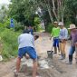 Warga Dusun Kuala Belian, saat sedang mengaduk semen untuk melakukan tambal sulam Jalan Iskandar Zeen. (Dedi Irawan)
